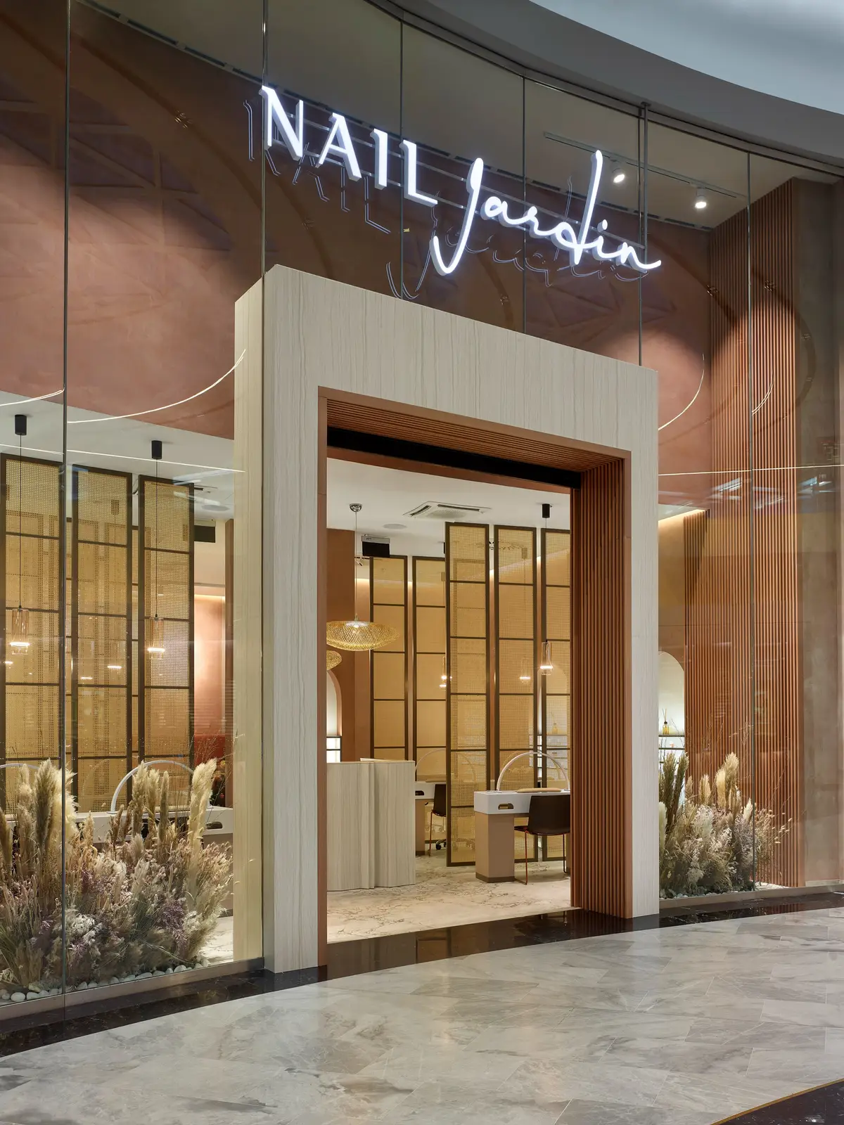 Vstup do Nail Jardin s teplým osvětlením a dekorativními příčkami